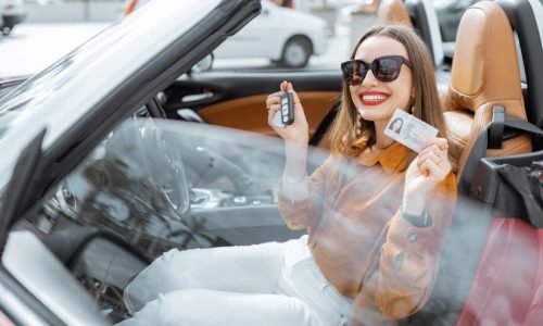 Portrait of a happy woman in the car Portrait of cheerful woman feeling happy while sitting in the new sports car. Concept of a happy car buying or renting